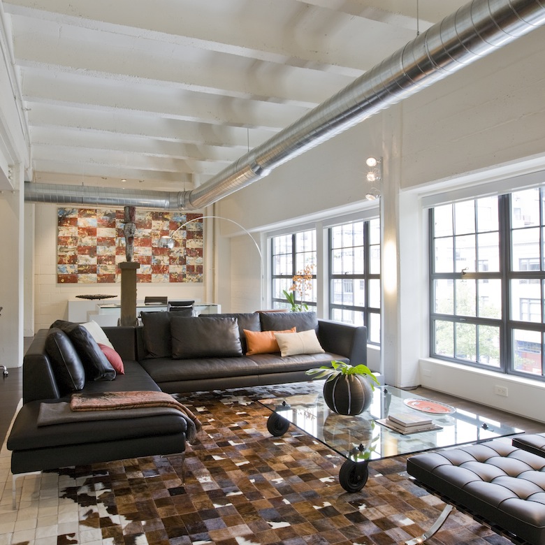 Iconic classic furniture juxtaposes the industrial feel of this Washington, DC loft, second home for an international power couple, with cement ceilings and exposed ductwork