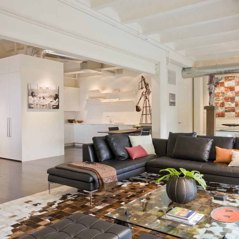 Featuring a clean white kitchen and exposed ceilings, this loft, a second home for an international power couple, is the perfect blend of modern and industrial styling