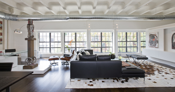 This contemporary Washington, DC loft, second home for an international power couple, features exposed ceilings and ductwork, classic furniture, and custom designed minimalist built-ins