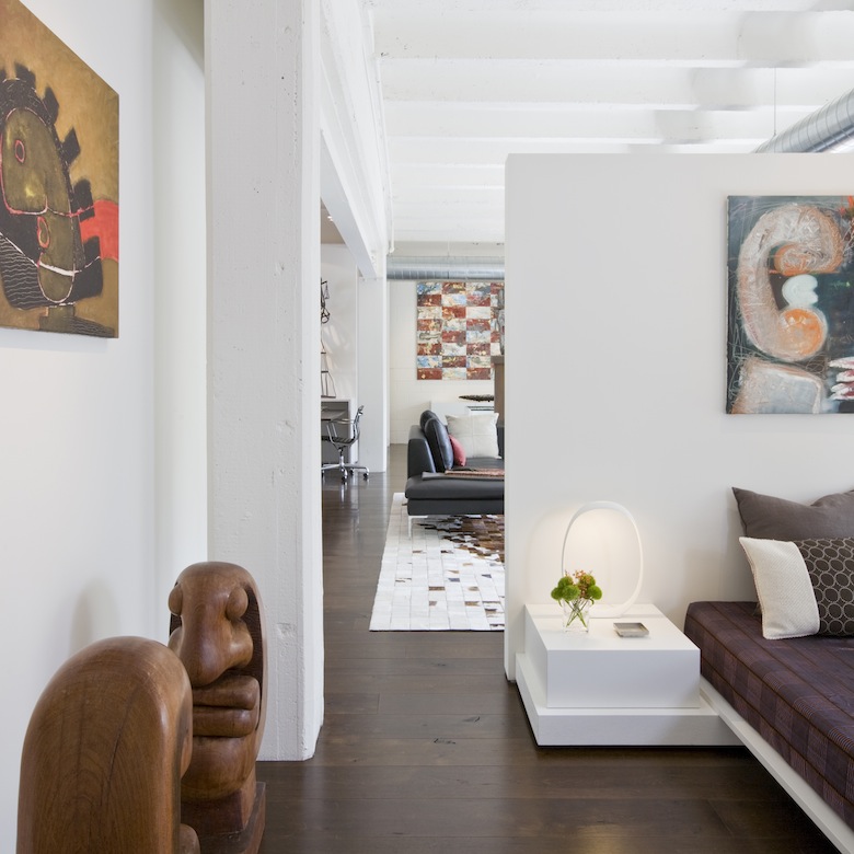 A short wall defines bedroom without chopping up the loft, second home for an international power couple, exposing the cement ceilings throughout the contemporary living space.