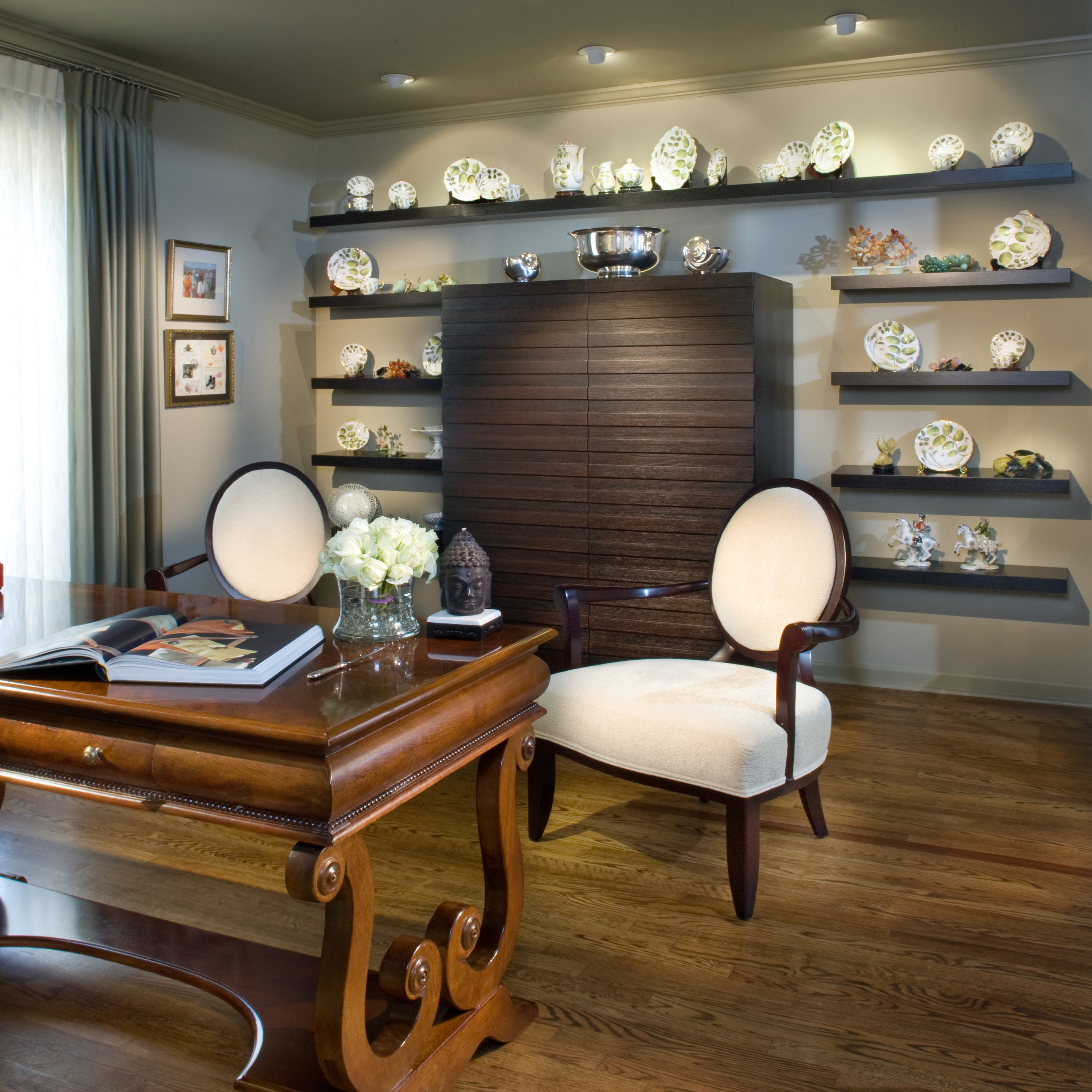 The client's antique china collection is displayed on upscale modern shelving, as opposed to dark curio cabinet.