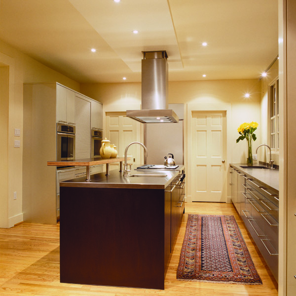 The remodeled contemporary kitchen of this Washington, DC colonial features stainless steel countertops and a large island.