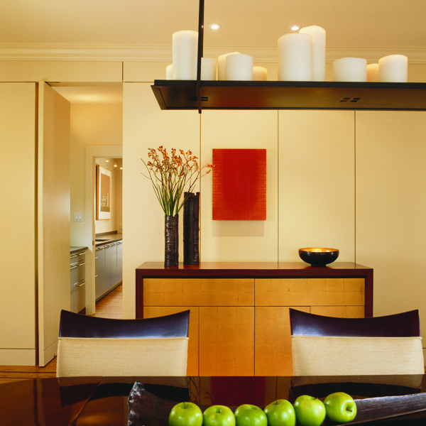 Contemporary paneling in this colonial renovation by Studio Santalla conceals a flush door to the kitchen