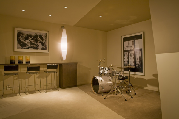 Neutral colors and large artwork define space in this open plan basement renovation by Washington, DC architect and interior design firm Studio Santalla