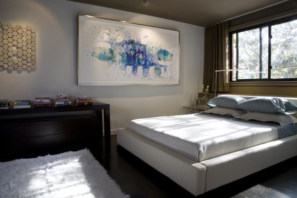 Modern artwork makes a bold statement in the bedroom of this condo by Washington, DC Architect and interior design firm Studio Santalla.