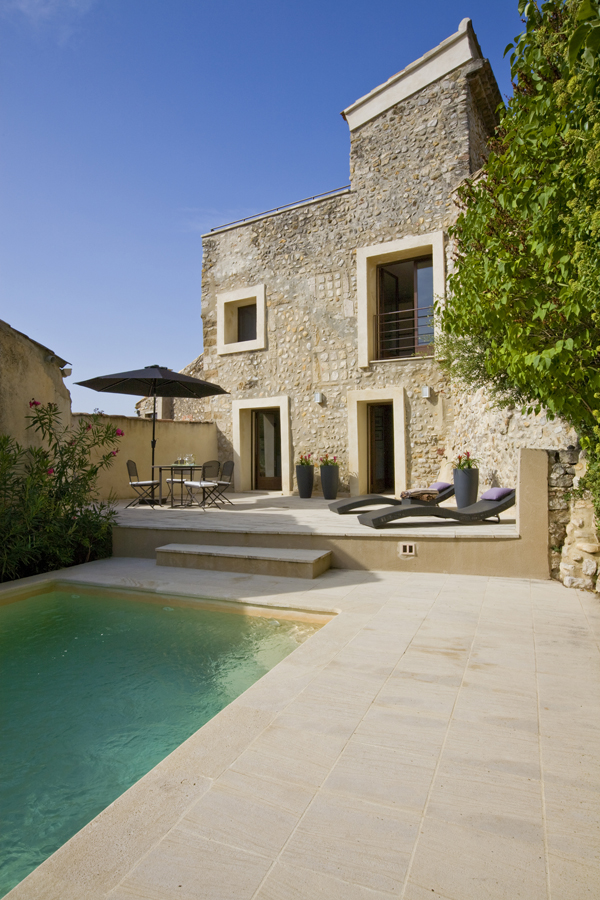 The elegant and simple pool deck and patio of an 800 year old french home renovation by Washington DC architect and interior design firm Studio Santalla.