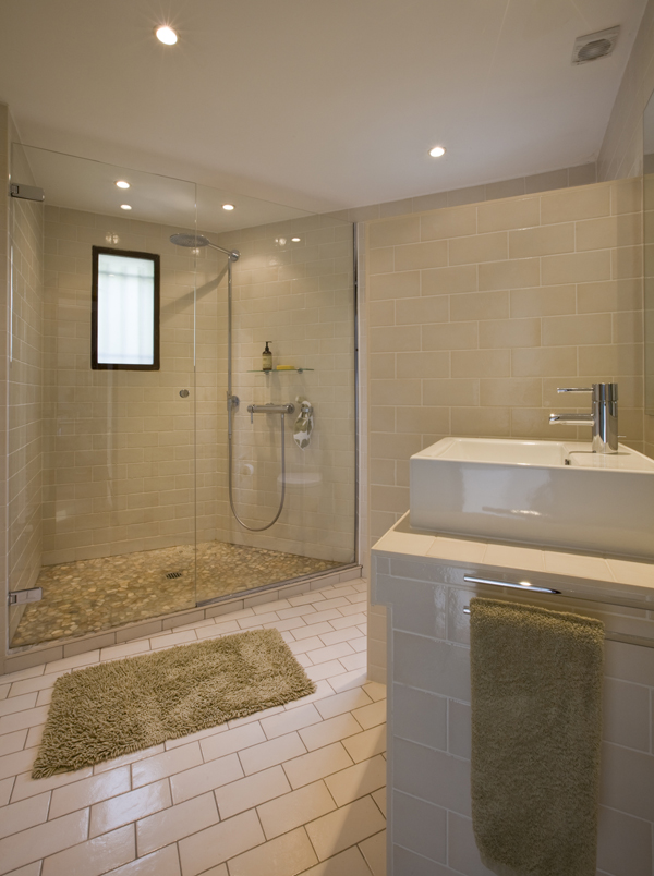 A simple glass shower occupies this oddly shaped bathroom by Washington, DC Architecture and Interior Design firm Studio Santalla