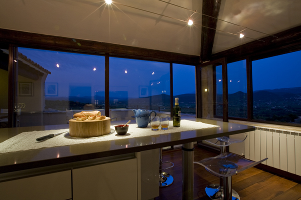 The eat-in kitchen of this renovation in Rasteau France overlooks the countryside, by Washington DC Architect and Interior Design Firm Studio Santalla