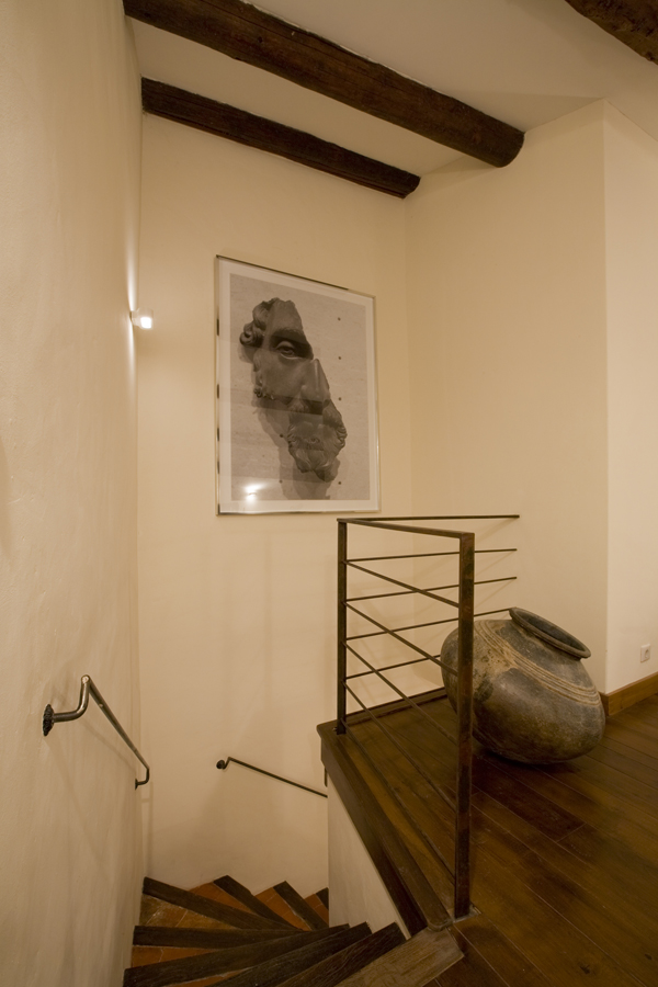 A large photograph overlooks the stairs in this 800 year old French home, restored by Washington DC Architect and Interior Design firm Studio Santalla.