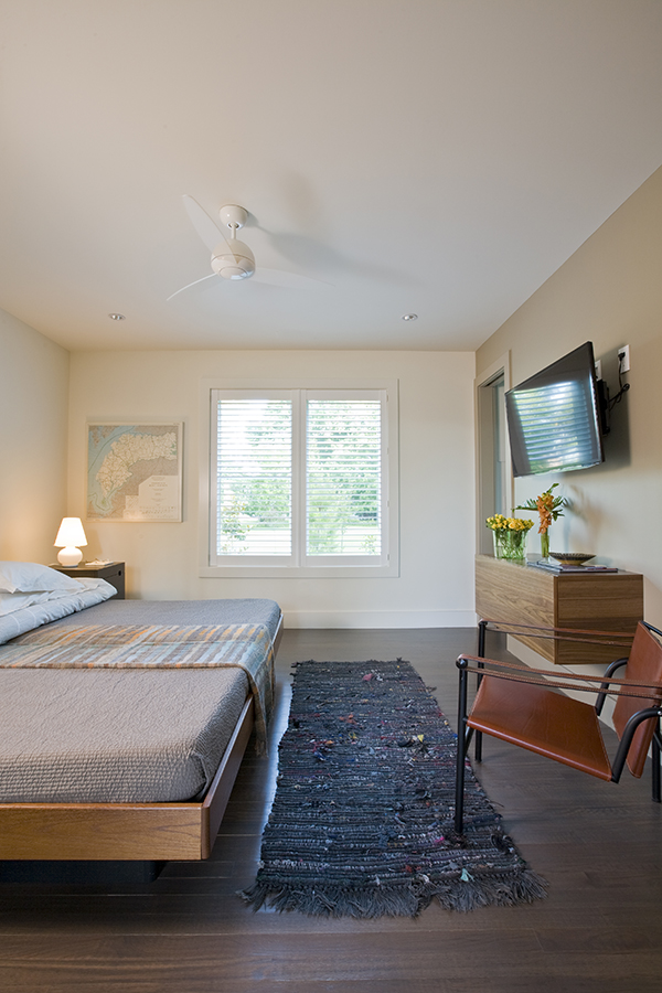 Clean and simple guest bedroom with floating dresser on the Eastern Shore by Washington, DC Architecture and Interior Design firm Studio Santalla