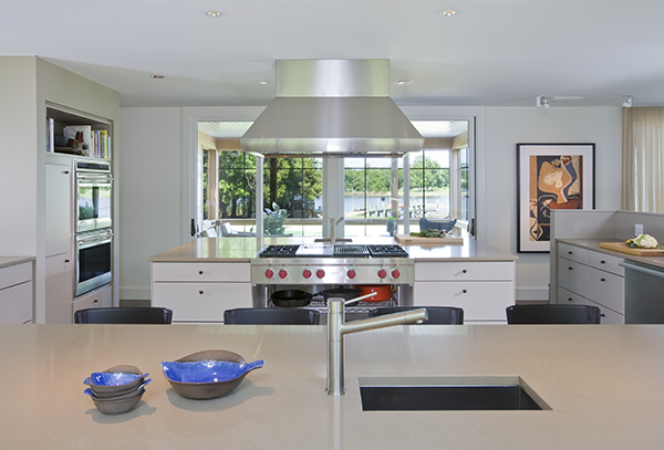 Massive, twin island kitchen in warm neutral colors with views of the Eastern Shore by Washington, DC Architecture and Interior Design firm Studio Santalla