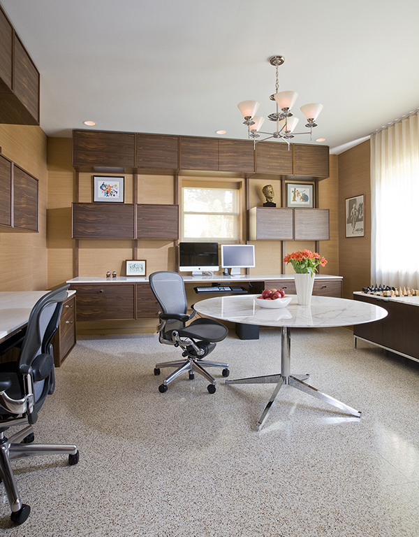 Custom floating desks inspired by midcentury classics provide ample workspace for two in this basement home office by Washington, DC architect and interior design firm Studio Santalla