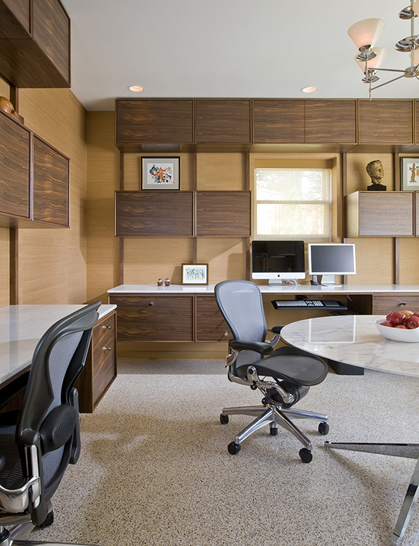 Custom floating desks inspired by midcentury classics provide ample workspace for two in this basement home office by Washington, DC architect and interior design firm Studio Santalla