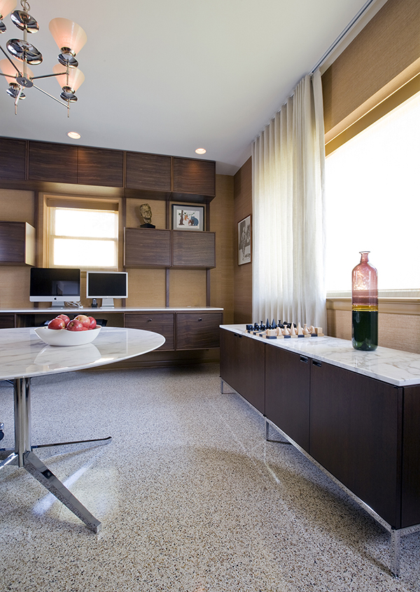 Custom floating desks inspired by midcentury classics provide ample workspace for two in this basement home office by Washington, DC architect and interior design firm Studio Santalla